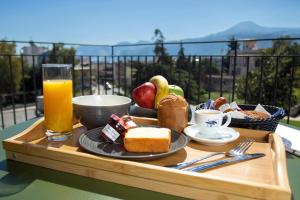 uma bandeja de comida para o pequeno-almoço e um copo de sumo de laranja em 11Suites em Aigio