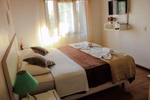 - une chambre avec un lit doté d'une fenêtre et d'une lampe verte dans l'établissement Pousada Cantinho, à Gramado