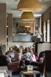 un gruppo di bambini seduti su sedie in un ristorante di Hotel Palisad a Zlatibor