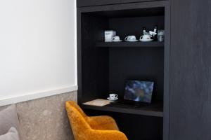 a room with a chair and a laptop on a shelf at 11Suites in Aigio