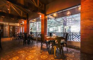 un restaurant avec des tables et des chaises et une grande fenêtre dans l'établissement Cloudchat, à Dharamshala