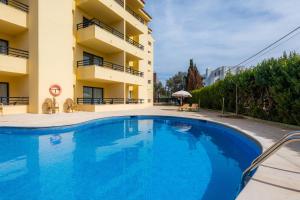 a swimming pool in front of a building at Apto con Terraza 401 in Cala Millor