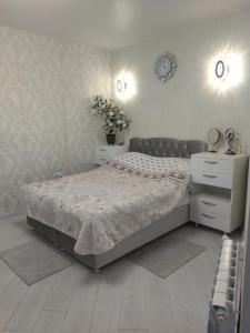 巴統的住宿－Квартира студия в Батуми，一间卧室配有床、梳妆台和鲜花