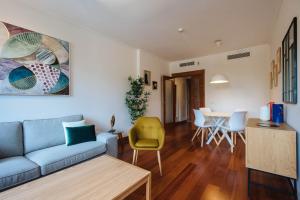 a living room with a couch and a table at Puerta del Príncipe - Free Parking in Seville