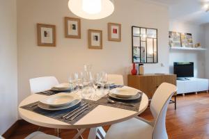 a dining room with a table and chairs and a television at Puerta del Príncipe - Free Parking in Seville