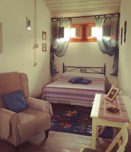 1 dormitorio con 1 cama, 1 sofá y 1 silla en Agriturismo Botro, en Pulicciano