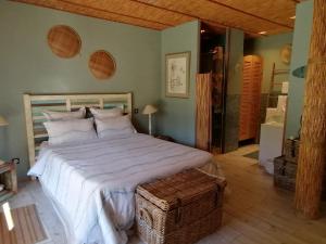 um quarto com uma grande cama branca e uma cabeceira em madeira em Via Bahia - Maison d'hôtes em Biscarrosse