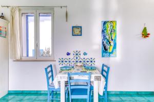 ガリアーノ・デル・カーポにあるNovaglie Mon Amourのダイニングルーム(テーブル、青い椅子付)