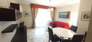 salon ze stołem i czerwoną kanapą w obiekcie Appartamento Sestri Levante Al Mare w mieście Sestri Levante