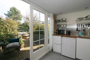 a kitchen with a sliding glass door leading to a patio at B&B Ereprijs in The Hague