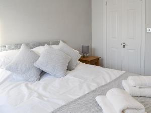 a white bed with white pillows on it at California Cottage - Uk42876 in Wilberfoss