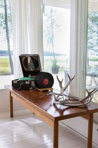 una mesa de madera con una cámara y cuernos en Villa Dyyni - South Facing - Seafront - Jacuzzi en Helsinki