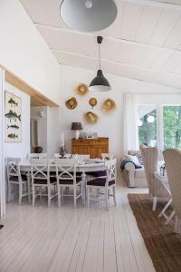 Villa Dyyni - South Facing - Seafront - Jacuzzi في هلسنكي: غرفة طعام بيضاء مع طاولة وكراسي
