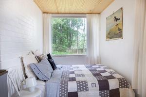 a bedroom with a bed and a window at Villa Dyyni - South Facing - Seafront - Jacuzzi in Helsinki