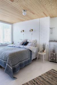 a white bedroom with a bed and a fireplace at Villa Dyyni - South Facing - Seafront - Jacuzzi in Helsinki