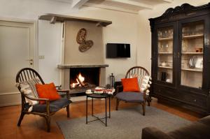 sala de estar con 2 sillas y chimenea en Como Lake Panorama Apartment Sveva en Cernobbio