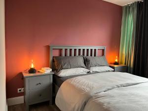 Un dormitorio con una cama y una pared roja. en My Place Holiday Appartments, en Garding
