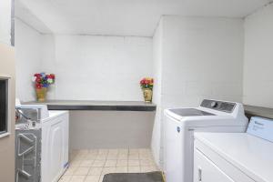a white laundry room with a washer and dryer at OYO Hotel Brownsville TN I-40 in Brownsville