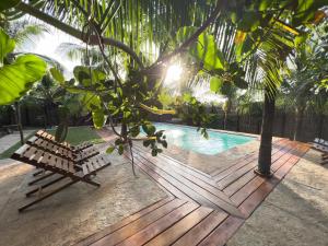a wooden deck with a bench next to a swimming pool at Lagoa do Vento - Atins in Atins