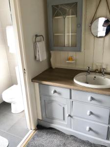 a bathroom with a sink and a mirror at Westend Bar & select accommodation in Fenit
