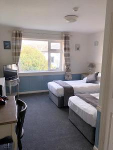 a hotel room with two beds and a window at Westend Bar & select accommodation in Fenit