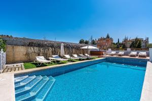 einen Pool mit Liegen und Stühlen neben einem Gebäude in der Unterkunft Cumbres Verdes in La Zubia