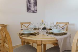 una mesa de madera con platos y vasos. en Nice apartment in Riviera del Sol Calahonda, en Málaga