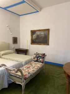 a bedroom with two beds and a bench with a pillow at Gavene in Villamagna
