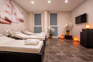 a room with three beds and a flat screen tv at PLAZA Premium Berlin Kurfürstendamm in Berlin