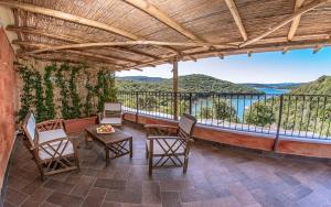 a room with a balcony with a table and chairs at Hotel Aldiola Country Resort in Sant Antonio Di Gallura