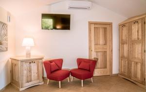 una sala de estar con 2 sillas rojas y una lámpara. en Hotel Aldiola Country Resort, en Sant'Antonio di Gallura