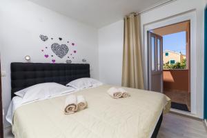 um quarto com uma cama com chinelos em Guest House Marinna em Vrboska