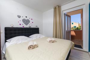 a bedroom with a bed with slippers on it at Guest House Marinna in Vrboska