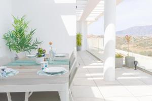 Biała jadalnia ze stołem i balkonem w obiekcie Luxurious penthouse in La Cala Casa Banderas - 3 Golf Facilites close by! w mieście La Cala de Mijas