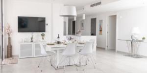 Biała kuchnia z białym stołem i białymi krzesłami w obiekcie Luxurious penthouse in La Cala Casa Banderas - 3 Golf Facilites close by! w mieście La Cala de Mijas
