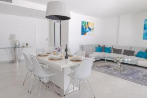 Biały salon z białym stołem i krzesłami w obiekcie Luxurious penthouse in La Cala Casa Banderas - 3 Golf Facilites close by! w mieście La Cala de Mijas