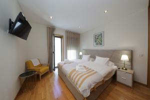 una camera con un grande letto e una televisione di Luxury Townhouse, in Tavira Centre with shared pool a Tavira