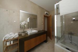 Un baño con lavabo, espejo y bañera. en Luxury Townhouse, in Tavira Centre with shared pool, en Tavira 19 fotos más