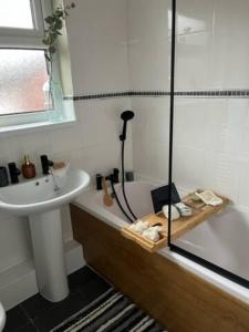 a bathroom with a shower and a sink and a tub at Modern cosy home sleeps 6 with parking nr Preston in Leyland