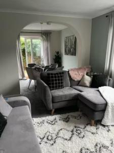 a living room with a couch and a table at Modern cosy home sleeps 6 with parking nr Preston in Leyland