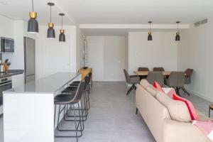 Una cocina y una sala de estar con un sofá y una mesa. en Amazing 3 bedroom apartment Cala Serena La Cala de Mijas, en La Cala de Mijas