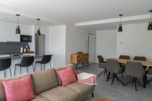 ein Wohnzimmer mit einem Sofa und einem Tisch mit Stühlen in der Unterkunft Amazing 3 bedroom apartment Cala Serena La Cala de Mijas in La Cala de Mijas
