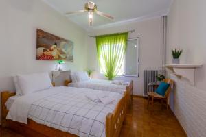 1 dormitorio con 2 camas y ventana en Casa Loula, en Corfú