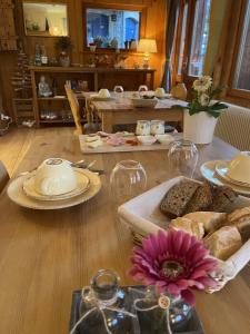 ein Esszimmer mit einem Tisch und Teller mit Lebensmitteln in der Unterkunft Le Manoir des Sens - Forêt de Bergheim in Thannenkirch