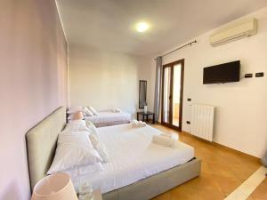 a bedroom with two beds and a flat screen tv at Maison Soleil Guest House Gallipoli in Gallipoli