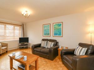 a living room with two couches and a tv at Home Waters in Weymouth