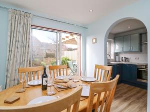 a kitchen and dining room with a wooden table and chairs at Home Waters in Weymouth