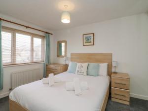 a bedroom with a large white bed and a window at Home Waters in Weymouth