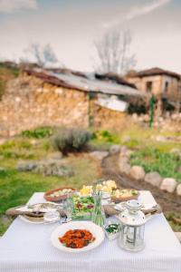 una mesa blanca con platos de comida. en Rancho i Vancho na Kata, en Omorani