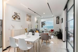 a living room with a white table and chairs at La Roca Chica in Torremolinos